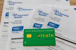carte vitale posée sur des relevés de prises en charge de l'assurance maladie