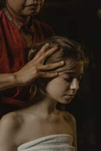 Massage du cuir chevelu : mains posées sur la tête d'une femme