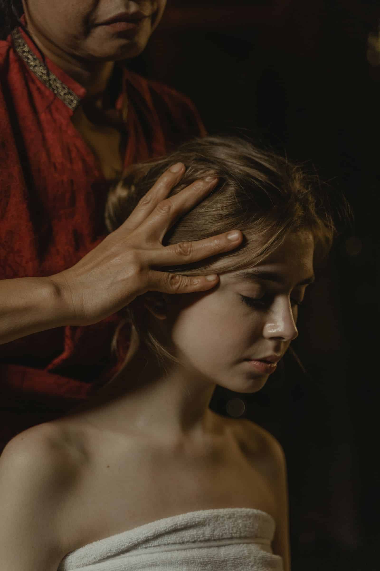 Massage du cuir chevelu : mains posées sur la tête d'une femme